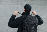 ASUS ROG Archer ErgoAir BP3800 – person justerer stropperne med rygsækken på ryggen