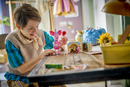 LEGO Disney 43305 – Grislingens fødselsdagssjov – Grisling og kagen på et bord med et barn