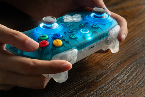 8BitDo Ultimate 2 Wireless 2.4G – Controller – Clear Blue – controller holdt i hænder